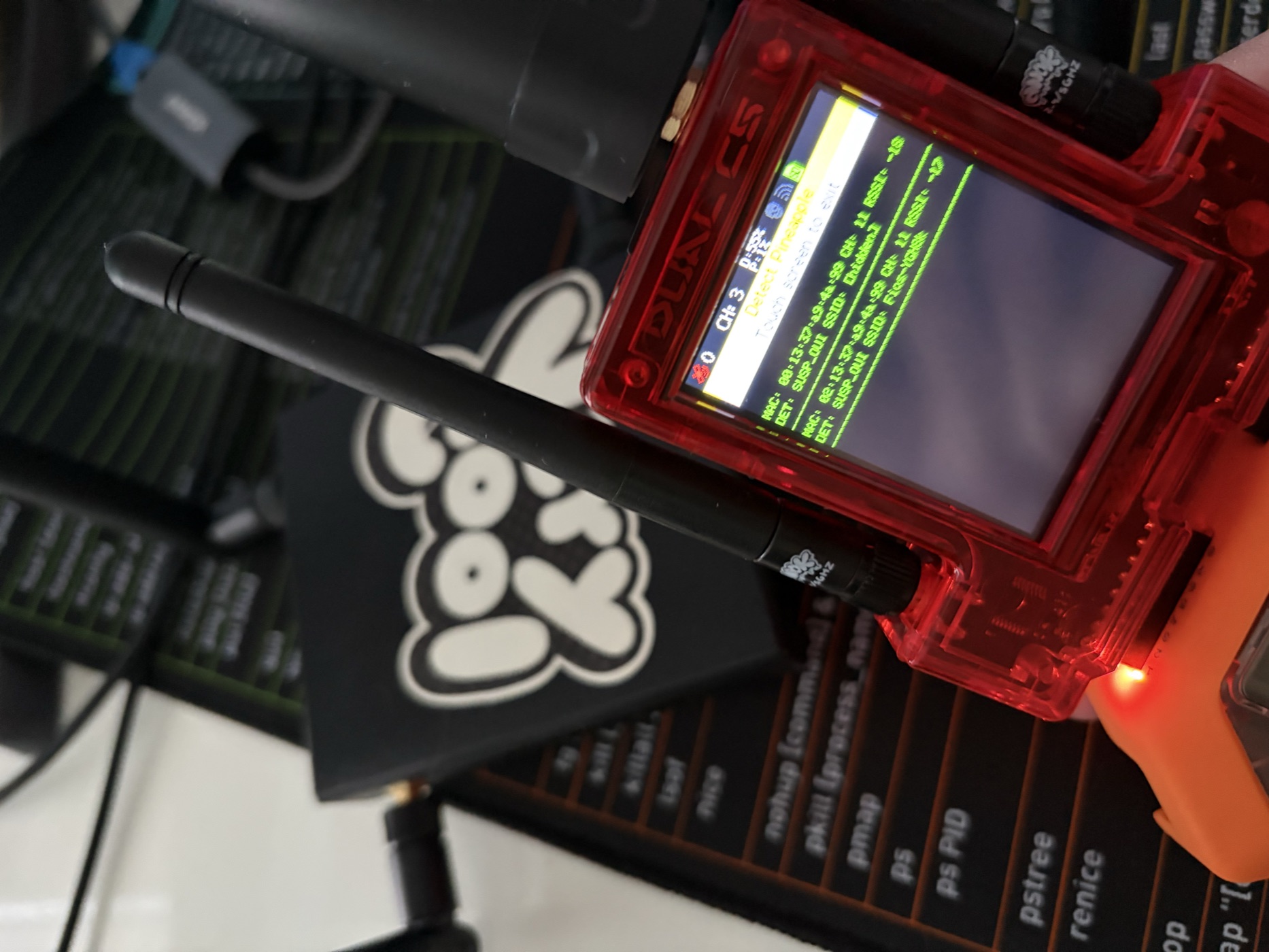A Marauder held over a desk, a sticker reading 'lookin?' visible on a laptop in the background.